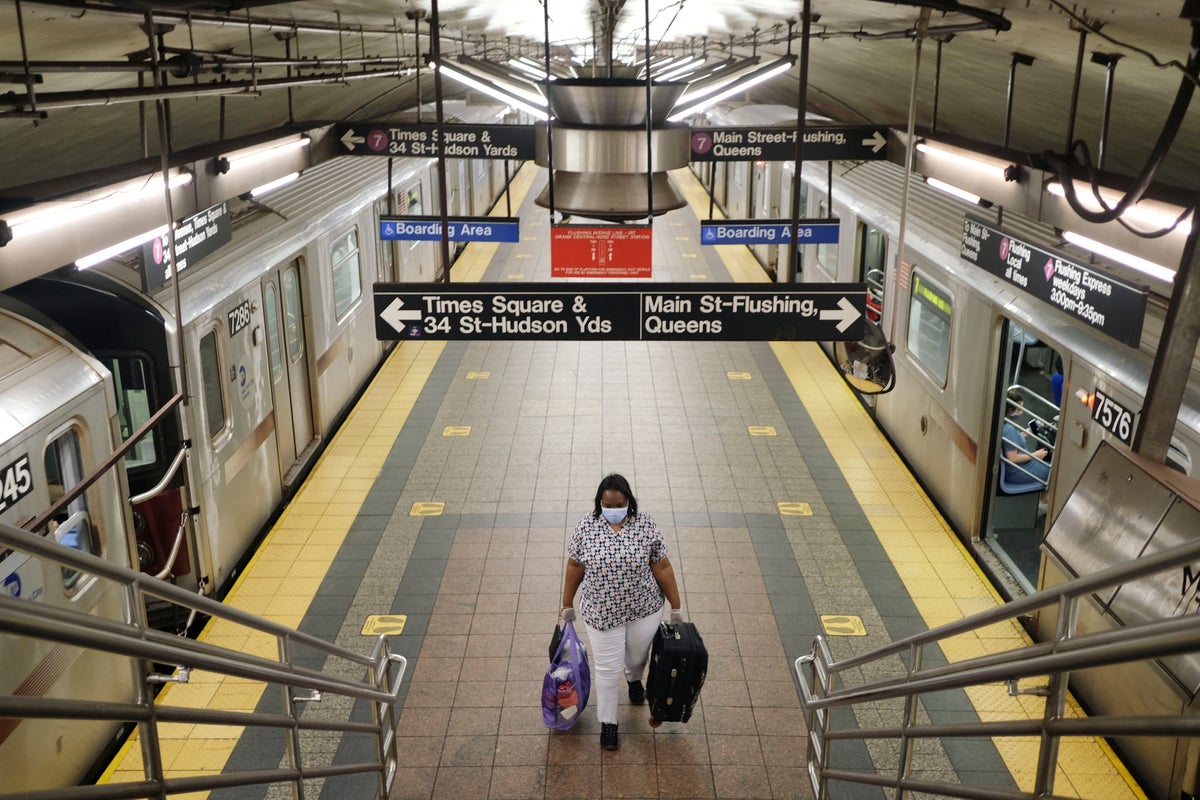 A commuter walks on a nearly empty subway platform in New York, Monday, June 8, 2020. After three months of a coronavirus crisis followed by protests and unrest, New York City is trying to turn a page when a limited range of industries reopen Monday. (AP Photo/Seth Wenig)