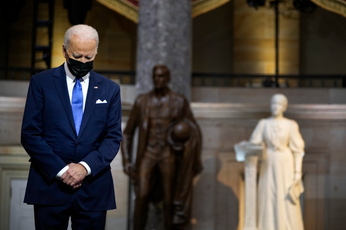 President Joe Biden listens as Vice President Kamala Harris speaks from Statuary Hall at the U.S. Capitol to mark the one year anniversary of the Jan. 6 riot at the Capitol by supporters loyal to then-President Donald Trump, Thursday, Jan. 6, 2022, in Washington. (Drew Angerer/Pool via AP)