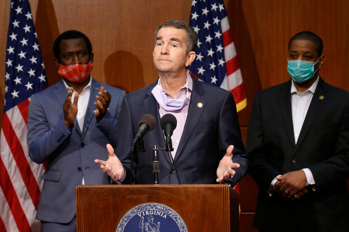 Virginia Gov. Ralph Northam, center, gestures as he announces his plans to remove the statue of Confederate General Robert E. Lee on Monument Avenue while Richmond Mayor Levar Stoney, left, and Lt. Gov. Justin Fairfax, right, look on, Thursday, June 4, 2020, in Richmond, Va. (AP Photo/Steve Helber)