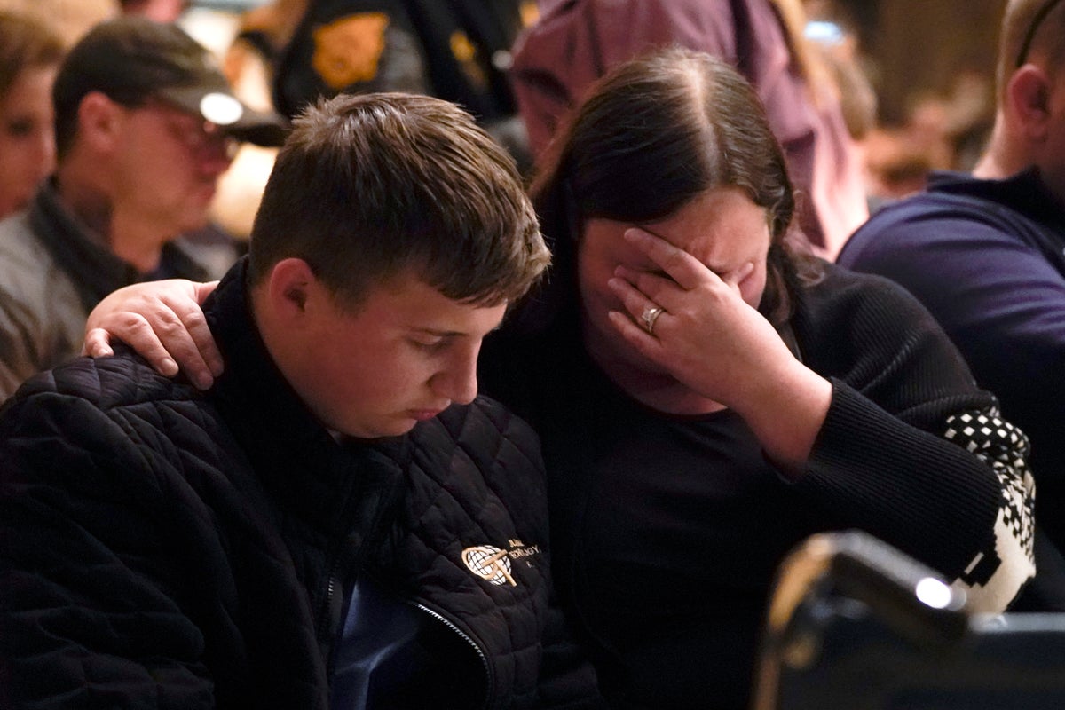 Aiden Watson, who was injured at Oxford High School, attends a vigil with his mother at LakePoint Community Church in Oxford, Mich., Tuesday, Nov. 30, 2021. Authorities say a 15-year-old sophomore opened fire at Oxford High School, killing several students and wounding multiple other people, including a teacher. (AP Photo/Paul Sancya)