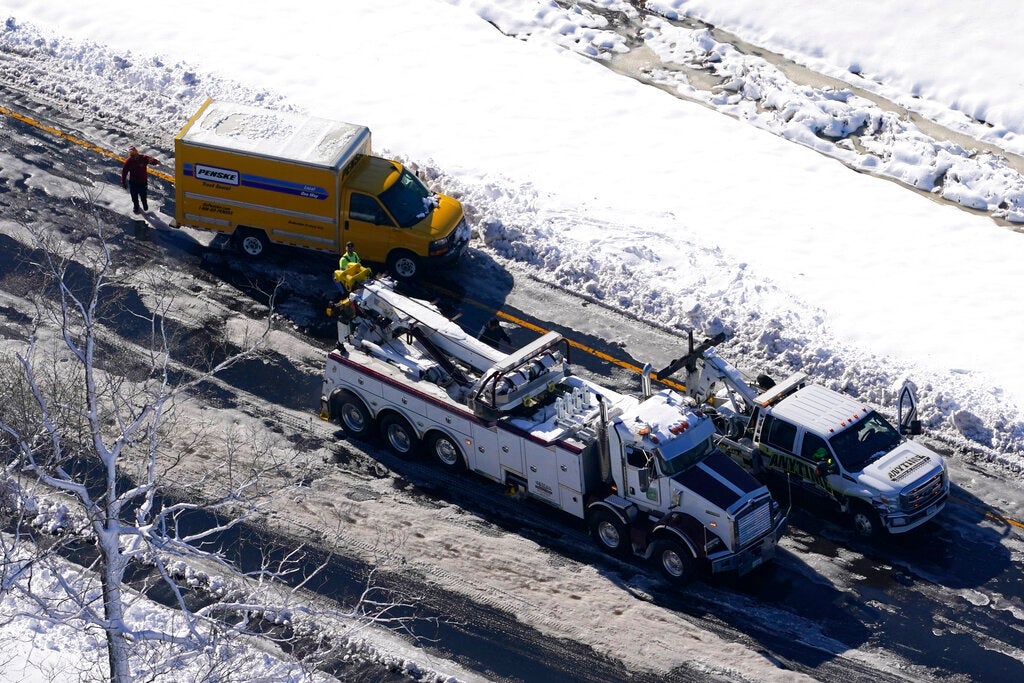 Workers remove cars and trucks stranded on sections of Interstate 95 Tuesday Jan. 4, 2022, in Carmel Church, Va. Close to 48 miles of the Interstate was closed due to ice and snow. (AP Photo/Steve Helber)