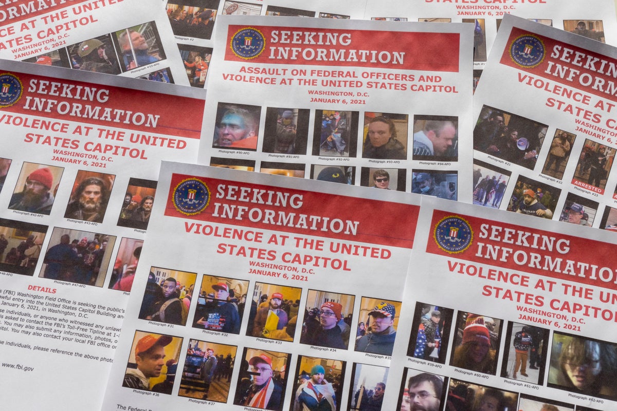 Seeking information flyers produced by the FBI are photographed on Dec. 20, 2021. The Justice Department has undertaken the largest investigation in its history with the probe into rioters who stormed the Capitol on Jan. 6. (AP Photo/Jon Elswick)
