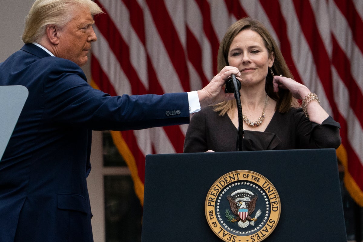 President Donald Trump adjusts the microphone after he announced Judge Amy Coney Barrett as his nominee to the Supreme Court, in the Rose Garden at the White House, Saturday, Sept. 26, 2020, in Washington. (AP Photo/Alex Brandon)
