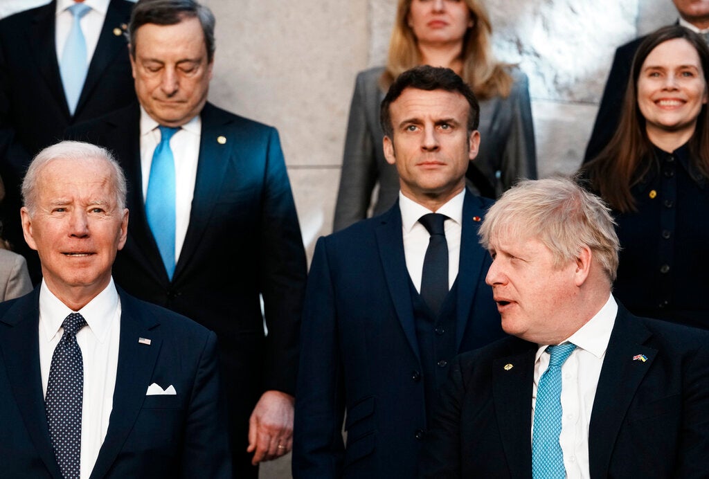 British Prime Minister Boris Johnson, front right, looks toward U.S. President Joe Biden, front left, at a group photo during an extraordinary NATO summit at NATO headquarters in Brussels, Thursday, March 24, 2022. As the war in Ukraine grinds into a second month, President Joe Biden and Western allies are gathering to chart a path to ramp up pressure on Russian President Vladimir Putin while tending to the economic and security fallout that's spreading across Europe and the world. (AP Photo/Thibault Camus)
