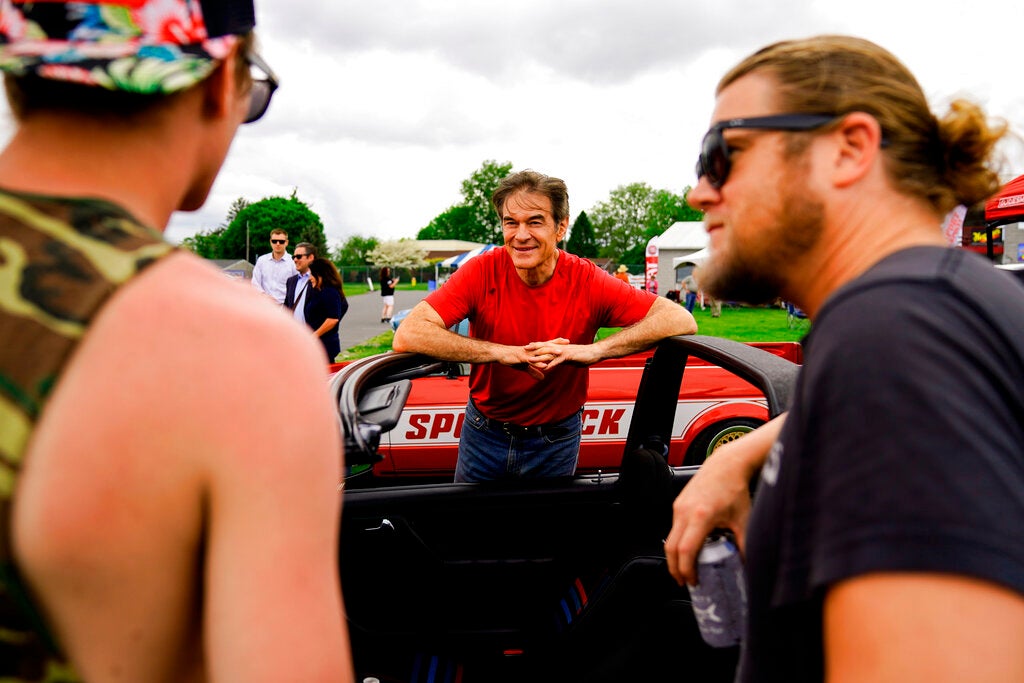 Mehmet Oz, a Republican candidate for U.S. Senate in Pennsylvania, meets with attendees during a visit to a car show in Carlisle, Pa., Saturday, May 14, 2022. (AP Photo/Matt Rourke)